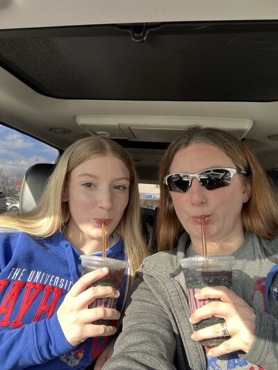 Megan and her daughter posing with iced drinks inside a parked car | Senior Photographer in Lawrence, KS