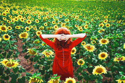 lovely-redhead-woman-enjoying-the-day-in-a-field-o-9B8BKNN