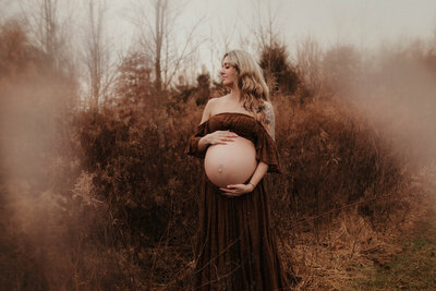 Photo of a couple hugging and having fun during their engagement photoshoot in a field in Bloomington Indiana.