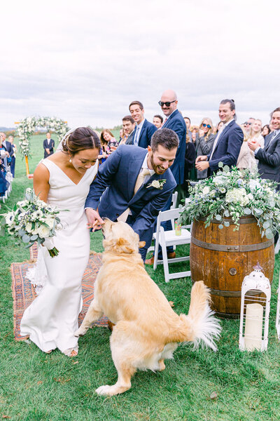 couple exiting outdoor ceremony at dog-friendly wedding weekend venue in Upstate New York