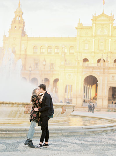 Couple kissing by the fountain at the Colonia Spanish Plaza in Seville Spain