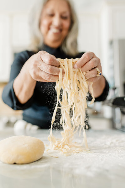 Culinary brand photograph featuring a chef making pasta from scratch