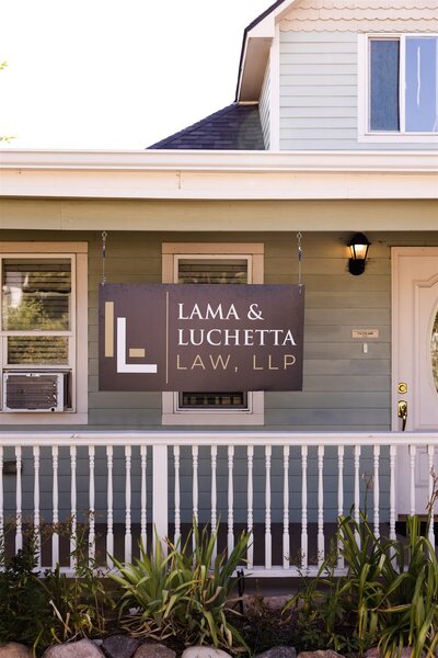 The front of the Colorado Springs office with a sign hanging down that says Lama & Luchetta Laa