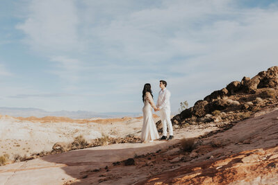 newlyweds stand on red rocks