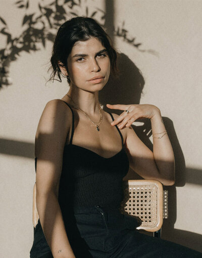 Jewelry model wearing necklace sitting on chair