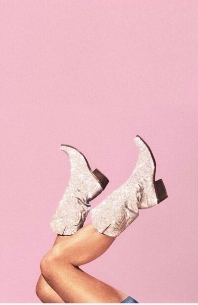 pink cowboy boots being kicked in the air