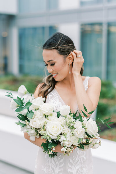 bride cradles all white and green bridal bouquet by roots floral design