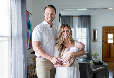 mom and dad holding newborn baby during fort worth newborn in home session with Allison Krogness Photography.
