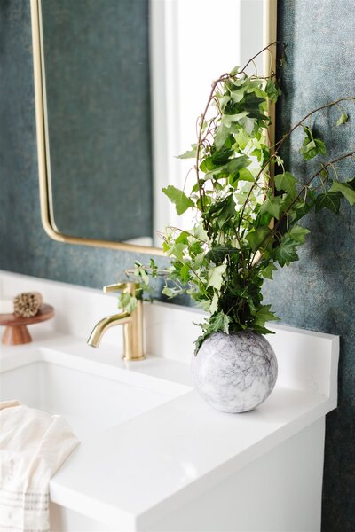 White bathroom countertop with gold faucet