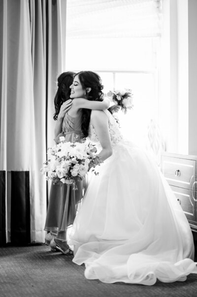 Bride hugging daughter in a historic room at the Mayflower wedding venue