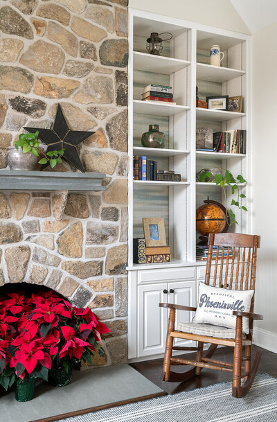 brick fireplace with white shelves and rocking chair