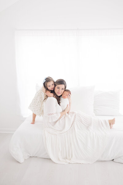 Newborn session in Connecticut with mother and father lovingly holding their newborn baby. The parents gaze at their child with deep affection, surrounded by a peaceful, natural setting