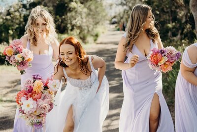 Bride and bridesmaids doubled over laughing during a fun, candid wedding shoot on the Central Coast.