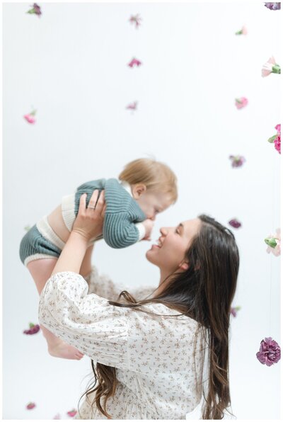 a-mom-is-holding-her-baby-in-the-air-and-smiling-up-at-him-for-her-motherhood-portraits-by-nashville-family-photographer-dolly-delong