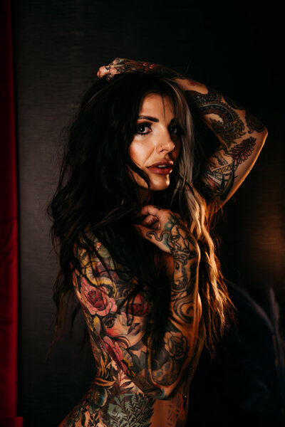 Boudoir photography nude woman with tattoos standing with hands in hair in Amarillo TX