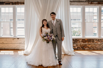 Portrait of bride and groom with white cloth background