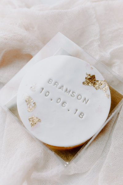 Clear boxed vanilla almond sugar cookie decorated with gold leaf and stamped "BRAMSON 10.06.18"