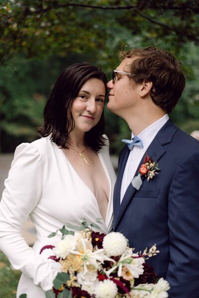 Brittanni and Derek sharing a kiss in their backyard wedding ceremony in Richmond, Virginia, documented with an editorial film aesthetic.
