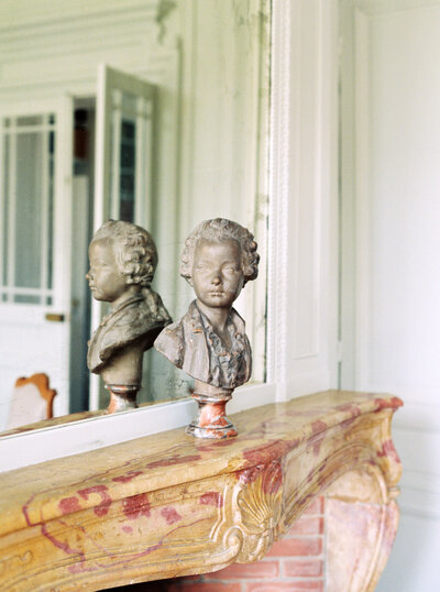 statue sits atop a fireplace mantle