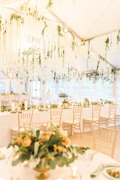 Wedding reception with hanging florals and gold chairs