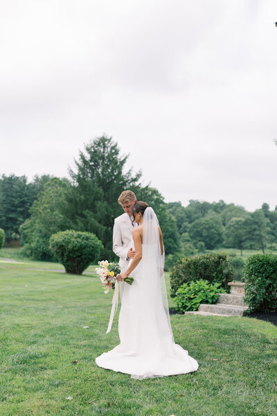 Wedding couple sitting on a wall at Virginia golf course wedding.