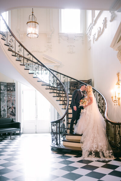 A couple posed on the stairs inside the Swan House