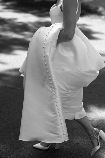 bride walking holding her dress at Wedding at the Whiteface Lodge in Lake Placid