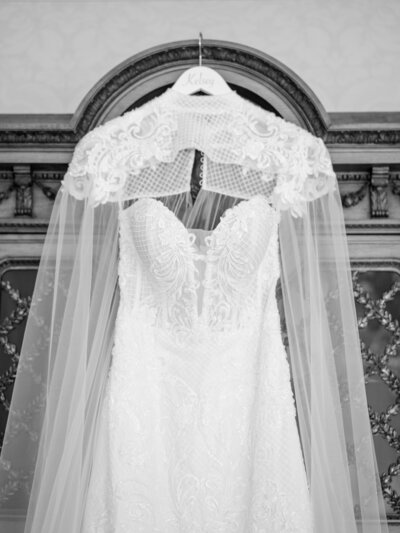 Fine art wedding photograph of bridal gown hanging in arched doorway – Fine Art Wedding Photographer Seattle