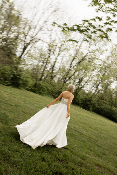 Bride twirling in her wedding dress with joy and grace, capturing a carefree and elegant moment on her special day.