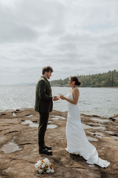 bride and groom saying vows on a rocky overlook on lake superior