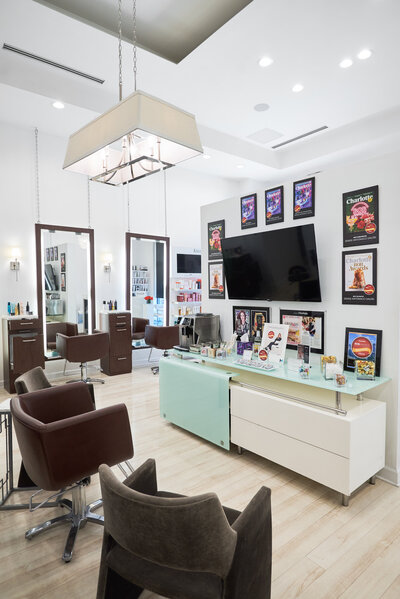 Modern and stylish interior of Denise Antonacci Salon in Charlotte, NC, featuring salon chairs, mirrors, product displays, and award plaques. Captured by DeLong Photography as part of a branding photography session with hairstylist Steph Dillard. Ideal example of professional salon branding photography in Charlotte.