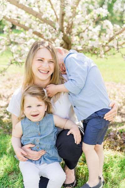Two children embrace their mother in a beautiful outdoor session in Minneapolis
