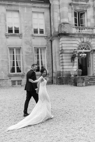 shoulder to knee photo of a bride wearing a wedding dress with a tight bodice and feathered of the shoulder trim