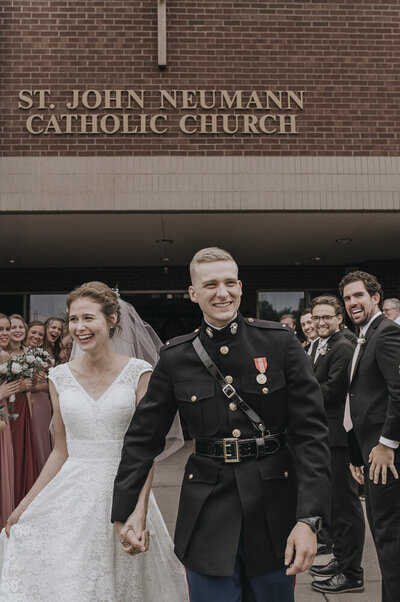 bride and groom smiling as they exit a church