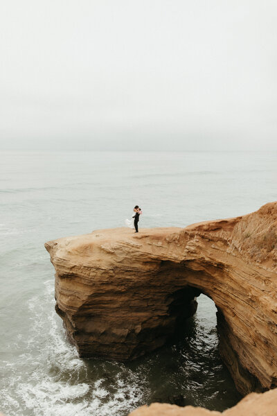 View of the sunset cliffs in san diego with the couple standing on one of the rocks