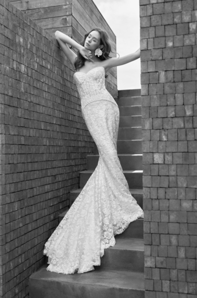 black and white image bride wearing strapless satin wedding dress with long train