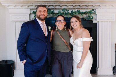 Denver intimate wedding photographer smiles with bride and groom on their wedding day.