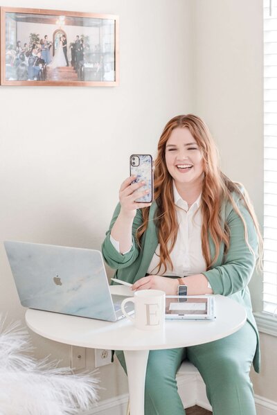 Friendly designer enjoying a FaceTime call with a client, discussing wedding invitation designs