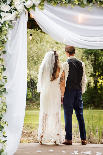 Image of newly wed couple, facing away from the camera looking into the distance, after their intimate New England wedding. 