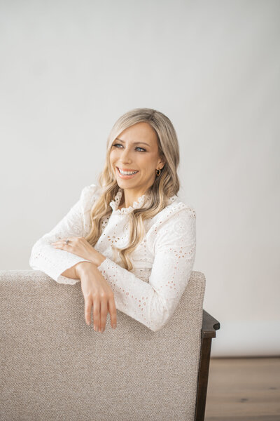 Dr. Tracy sitting in a chair smiling