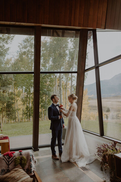 Bride helps groom get ready for their Telluride elopement