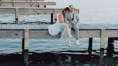 Bride rests her head on the grooms shoulder as they relax on the docks on Canandaigua Lake at the Lakehouse wedding venue