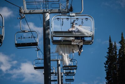 Bride and groom ride ski lift during Arapahoe Basin intimate wedding.