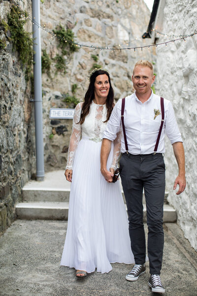 bride and groom walking on cobbled road