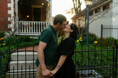 happy couple kissing in front of house
