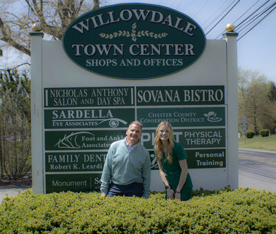 Dr. Leardi and staff member posing in front of the Willowdale Town Center sign