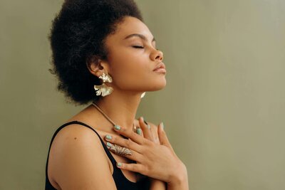 A woman with eyes closed and her hands on her chest