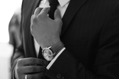 Man adjusting tie in suit