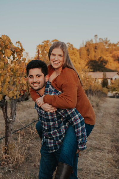 Couple piggy back rides in Placerville, CA.