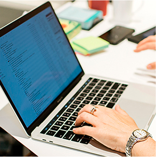 Image of Emily May typing at her laptop